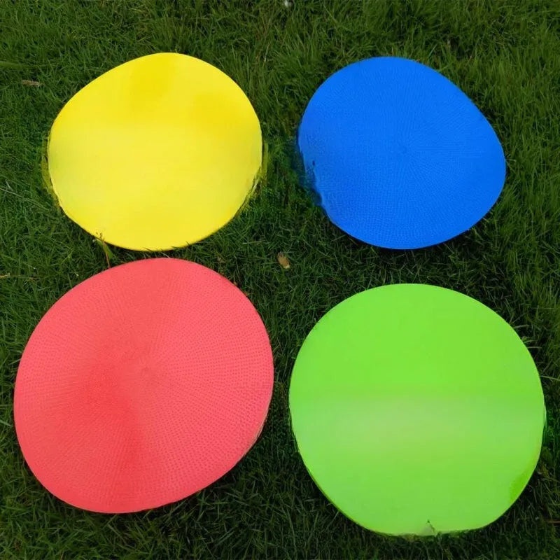 Flat yellow TPE football training landmark pad disc on grass, 23 cm in diameter.