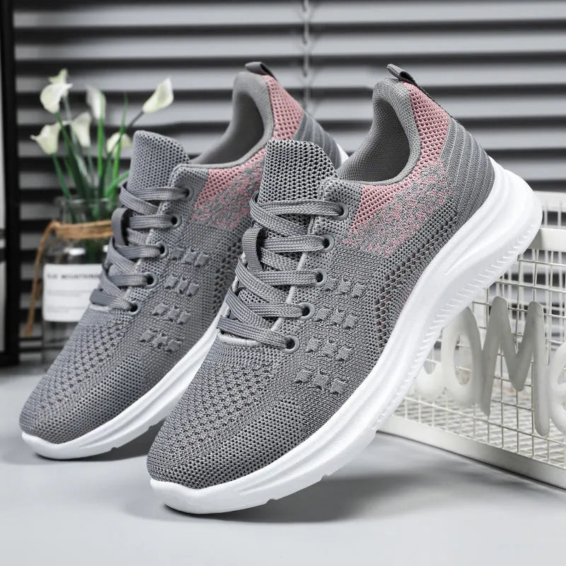 Women's low-top mesh sneakers with lace-up front and soft PVC sole in black, grey, or pink