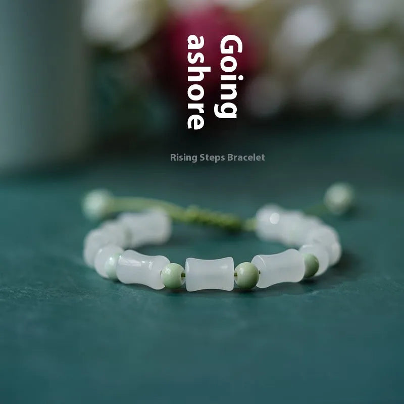 Chinese style handmade glass bead bracelet with bamboo joint elements on a white background.