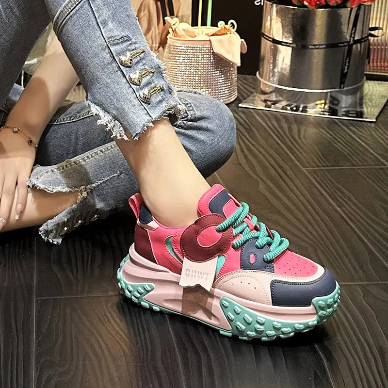 A pair of thick-soled leather casual shoes with a wedge heel and lace-up front fastening.