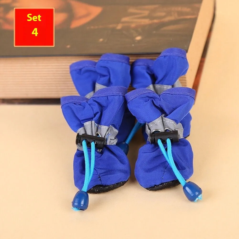 Set of four cloth dog shoes with soft soles in assorted colours on a neutral background