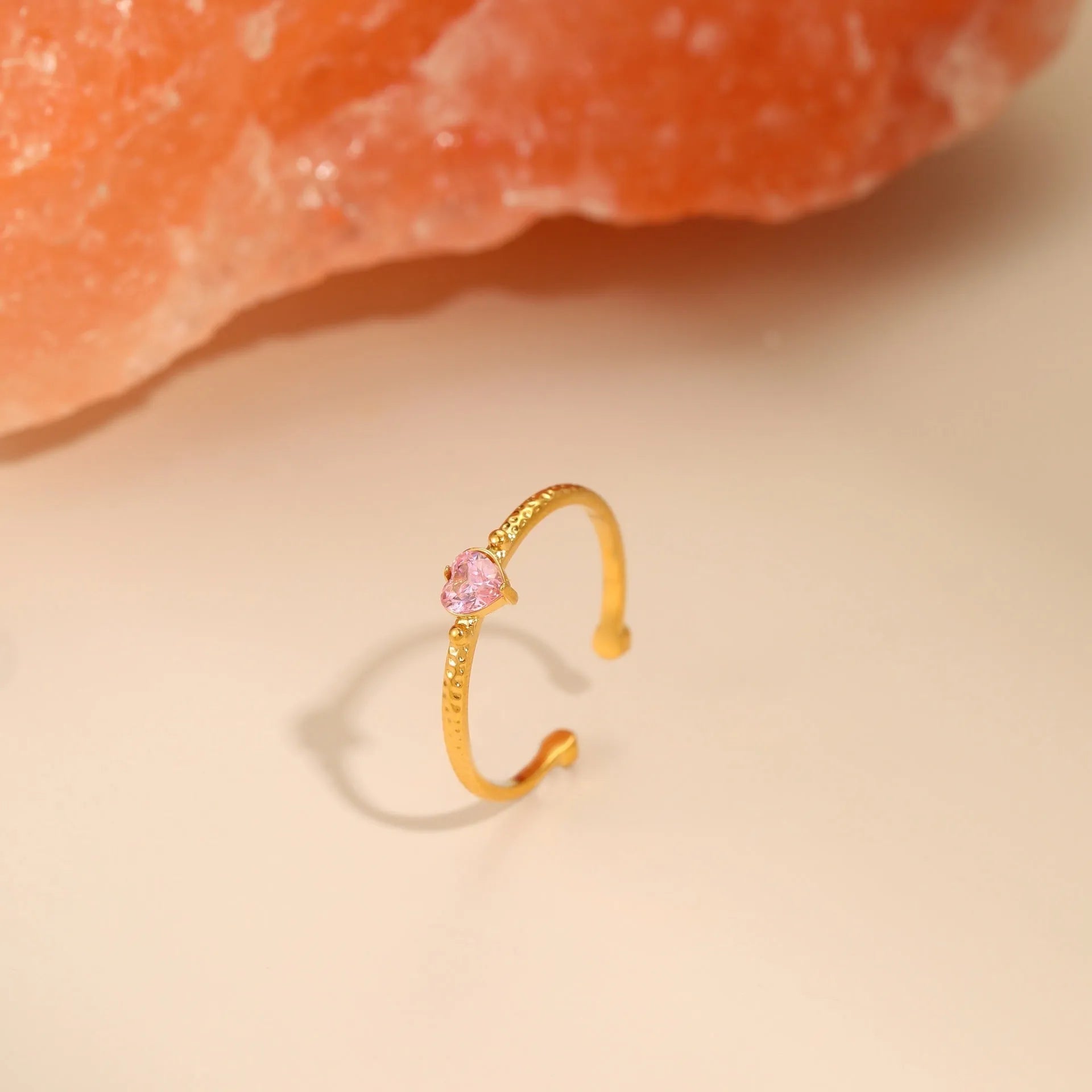 Open-ended geometric heart ring with a cubic zirconia stone on a silver-toned stainless steel band.