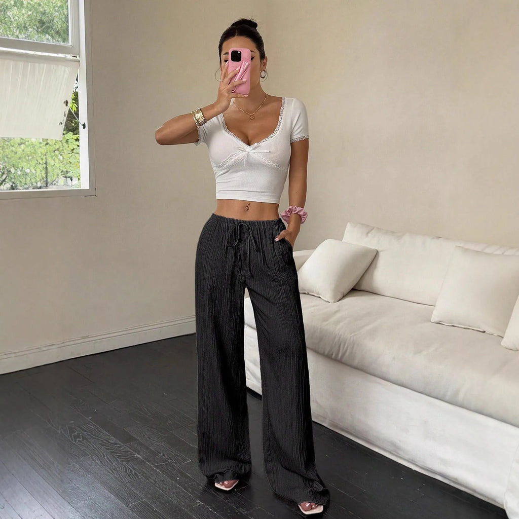 Women's black wide-leg trousers with lace-up waist trimming detail on mid-waist