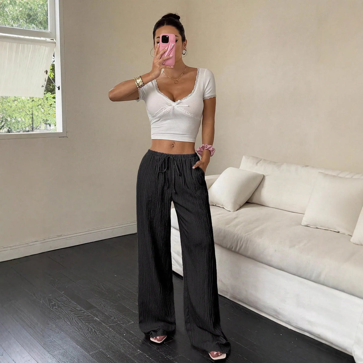 Women's black wide-leg trousers with lace-up waist trimming detail on mid-waist