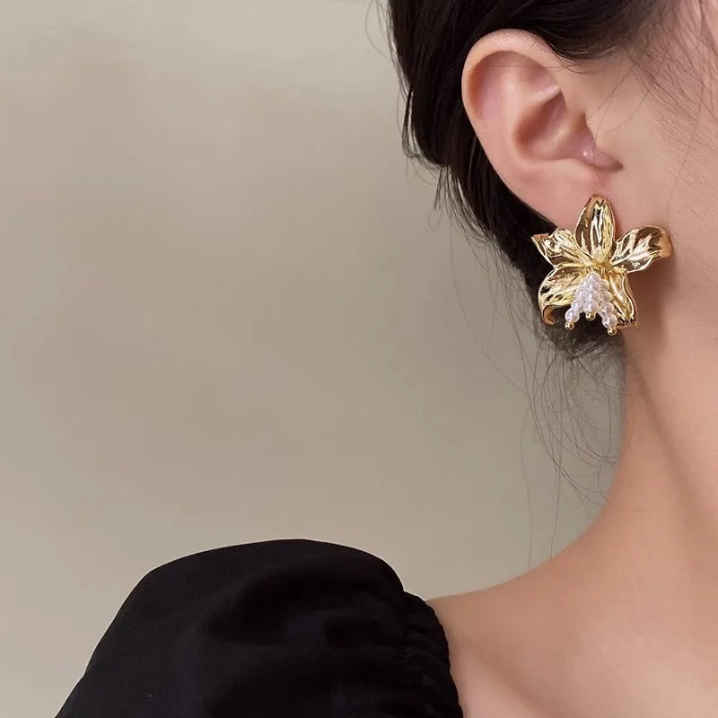 A pair of gold H1795 coloured flower-shaped drop earrings with a pearl centre.