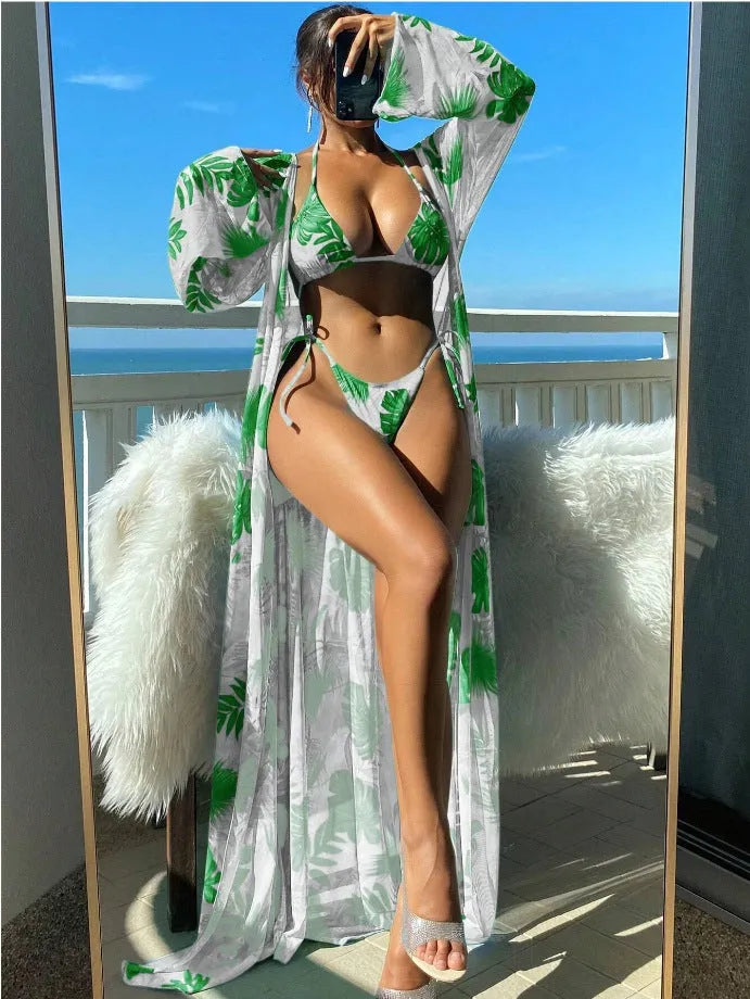 Women's blue long sleeve bikini top and banded briefs with a matching robe laid flat.