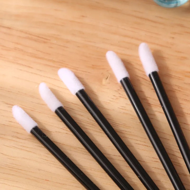 Pack of disposable lip brushes with flocked heads and coloured handles, shown in quantities from 200 to 500 pieces.