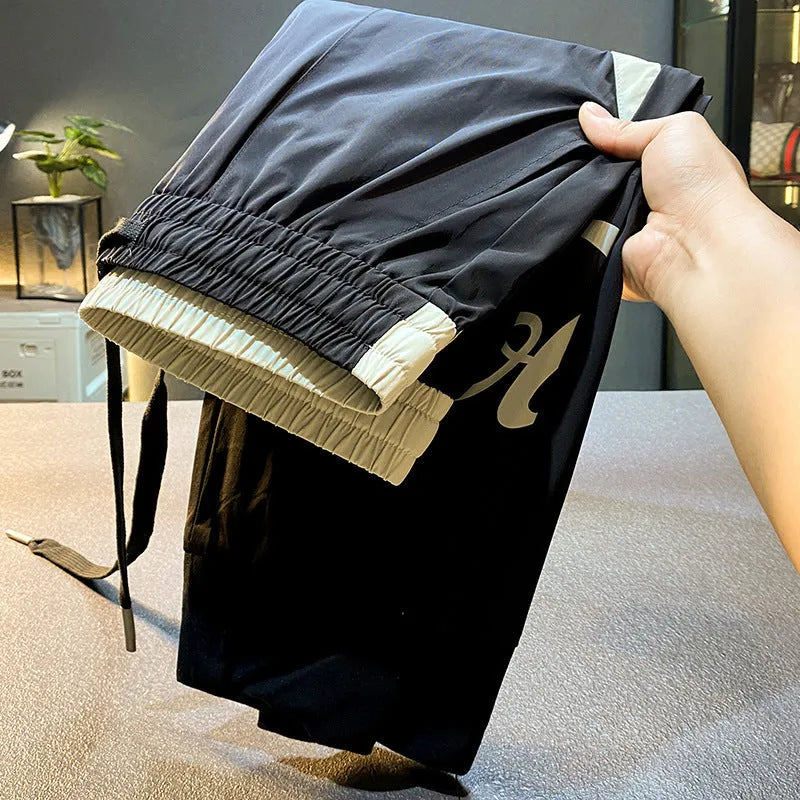 Black men's cropped casual trousers with an ankle band, made from thin Ice Silk cotton fabric.