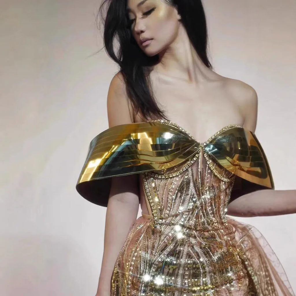 Gold strapless sequined dress with long split skirt on a mannequin
