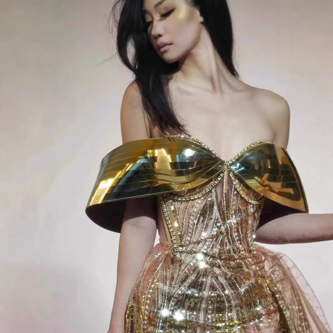 Gold strapless sequined dress with long split skirt on a mannequin