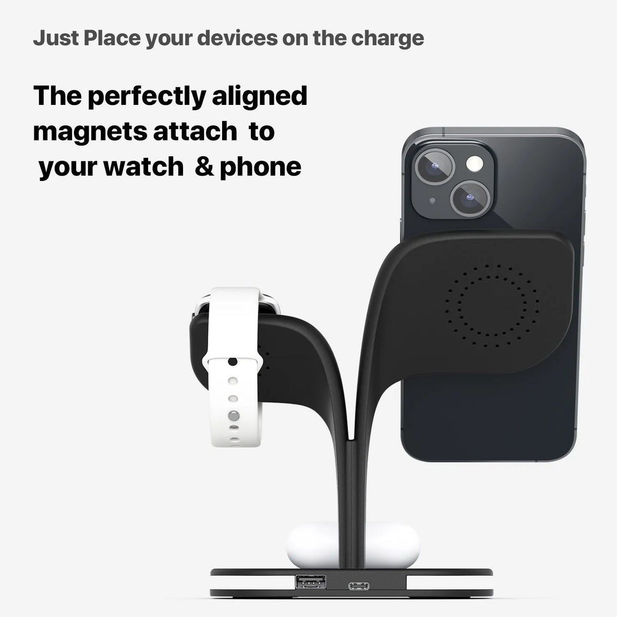 Black and white wireless charging stand for phone, watch, and headphones on a desk.