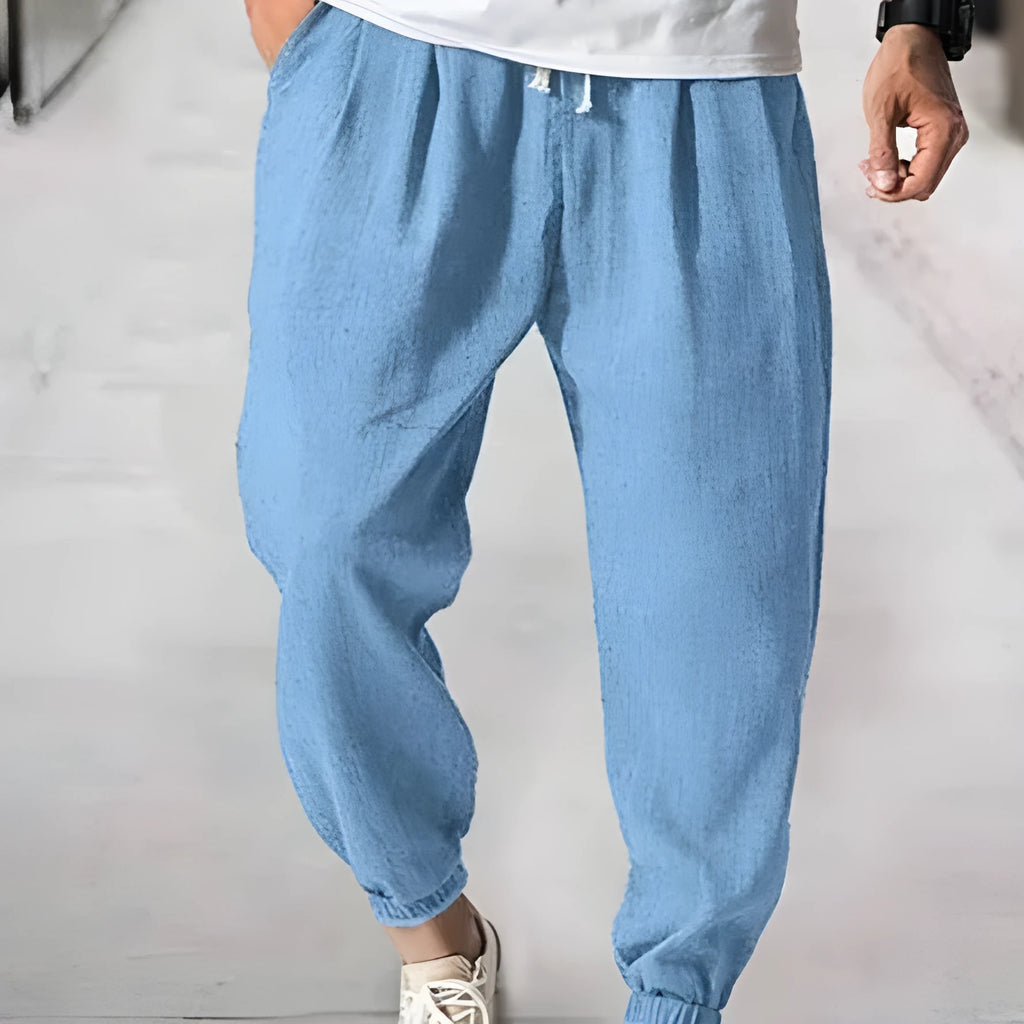 Men's loose-fitting cotton trousers with elasticated ankle bands in light green colour showing casual summer style