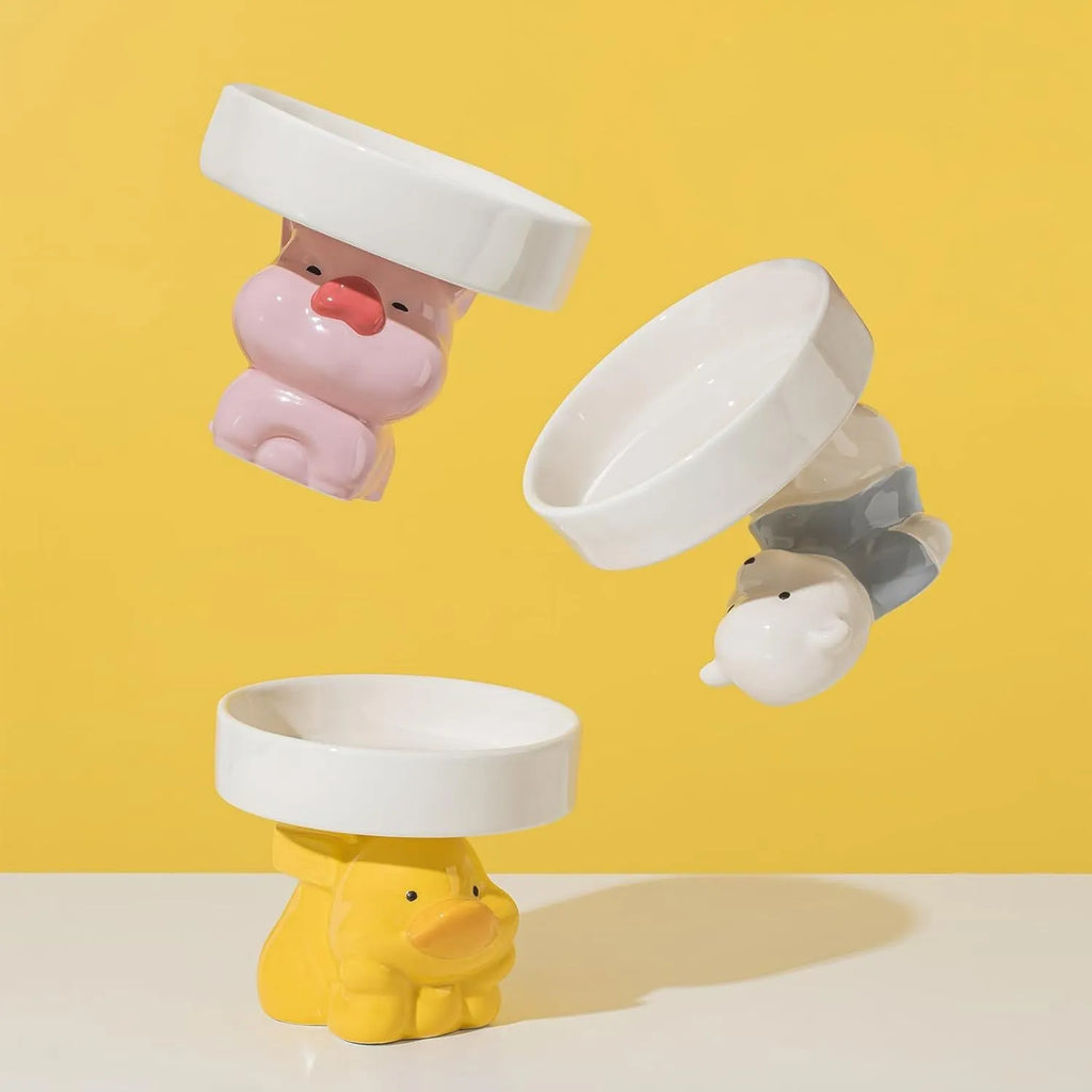 Ceramic raised cat bowl with cute animal design, shown in pink pig, white bear, and yellow duck styles.