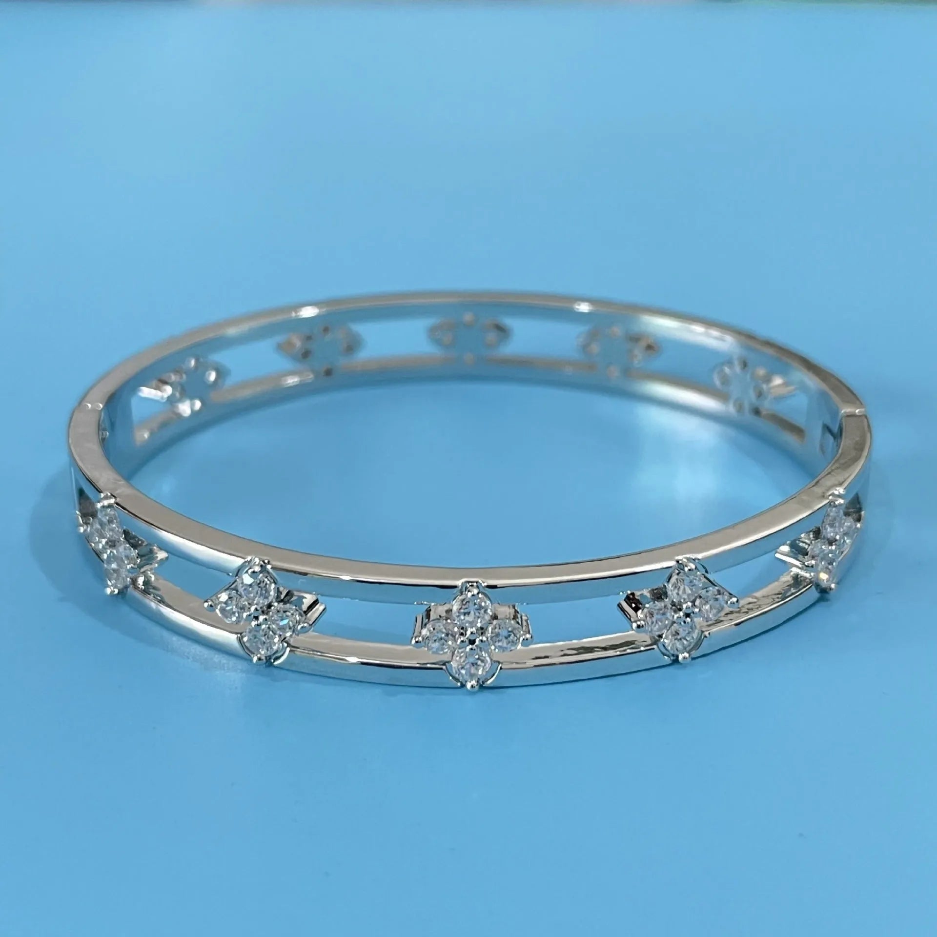 Gold and silver hollow women's bracelet with four-leaf clover design and zircon inlay.