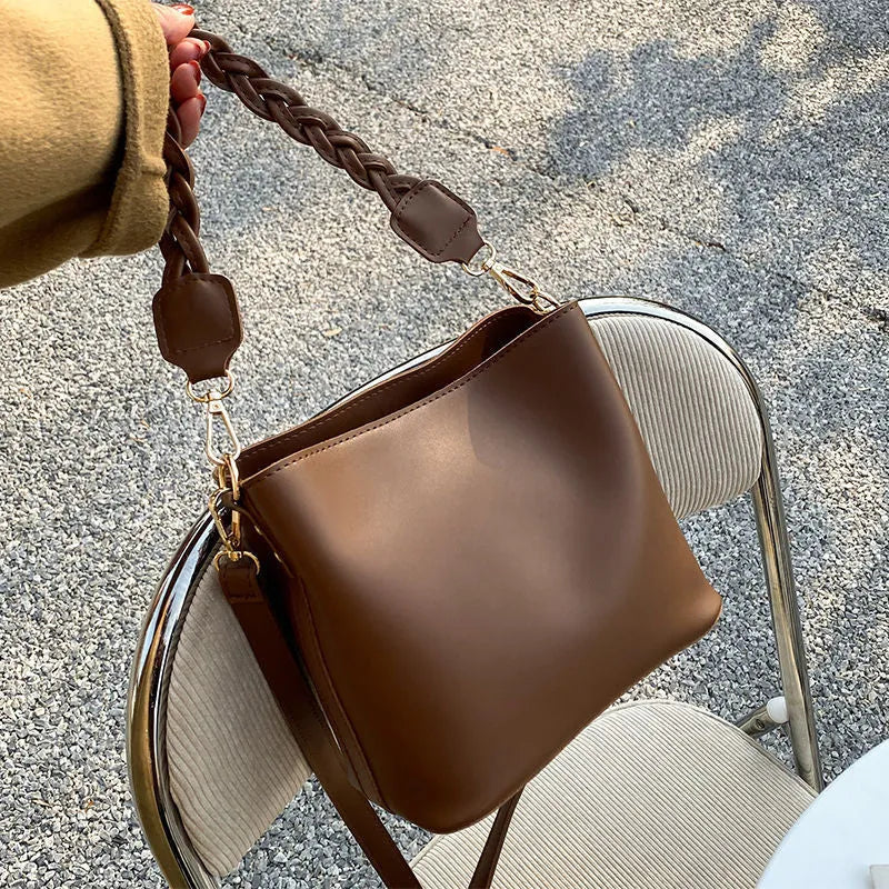 Unisex one-shoulder crossbody bucket bag in woven PU leather, shown in khaki colour.