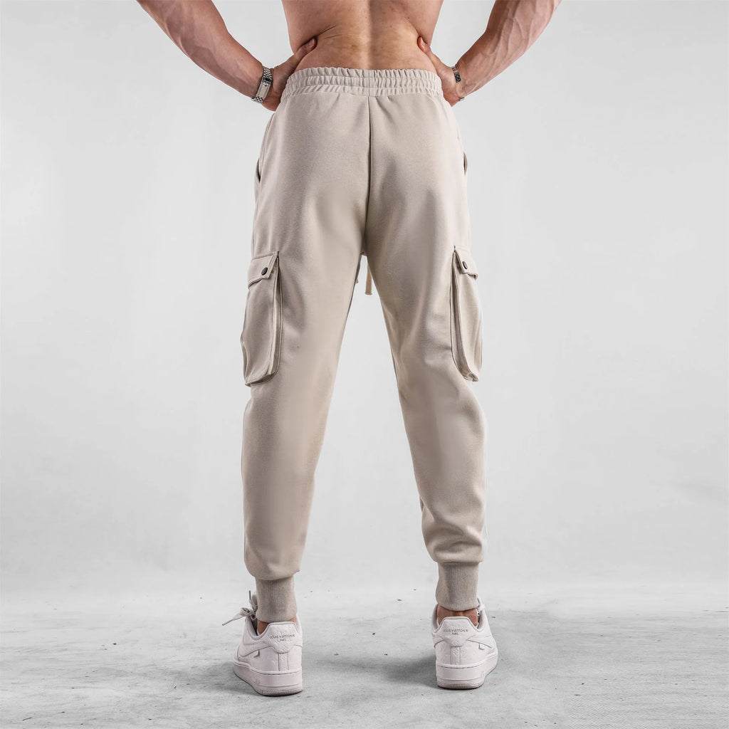 Men's loose cotton trousers with ankle ties and multiple pockets in solid apricot colour