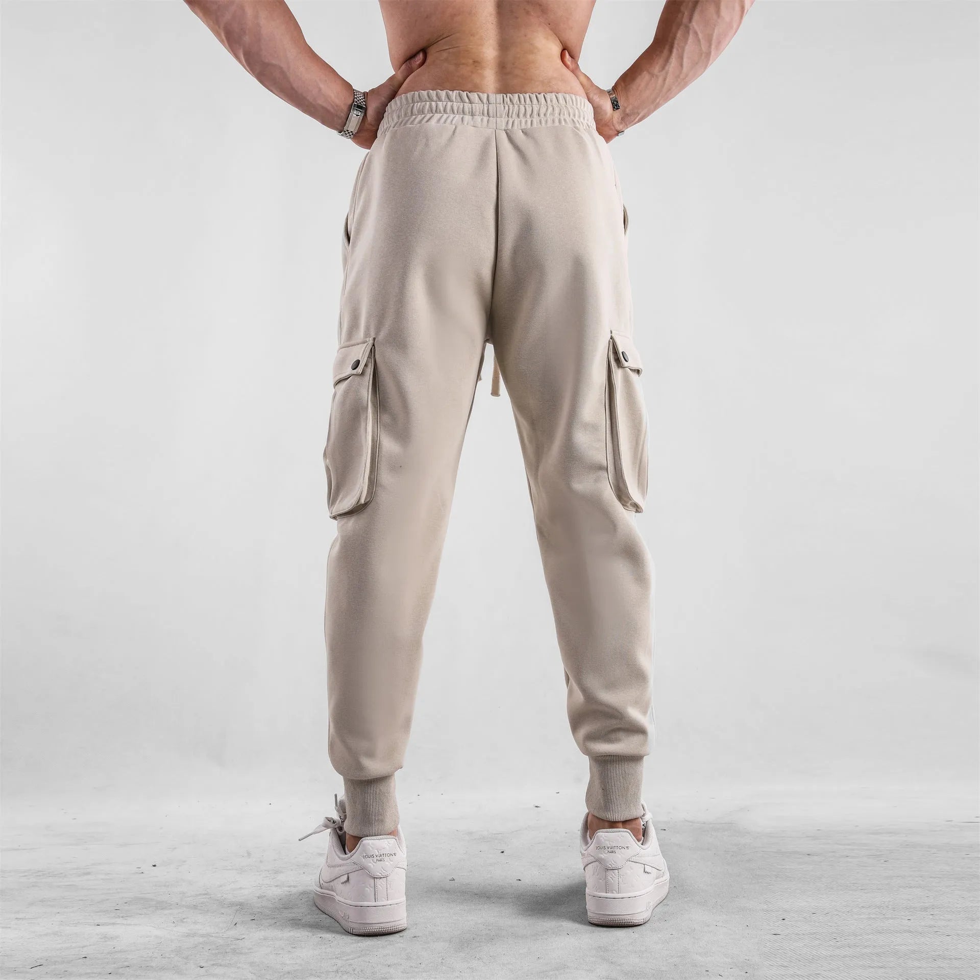 Men's loose cotton trousers with ankle ties and multiple pockets in solid apricot colour