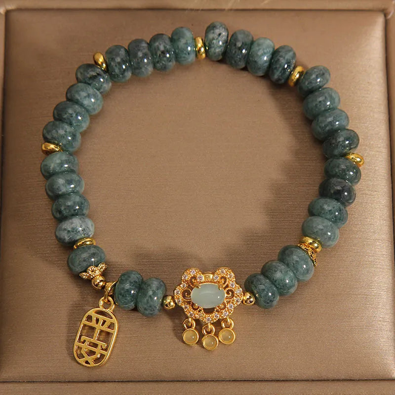 Close-up of a women's bracelet with green emerald jade abacus beads and a silver-toned alloy safety lock clasp.