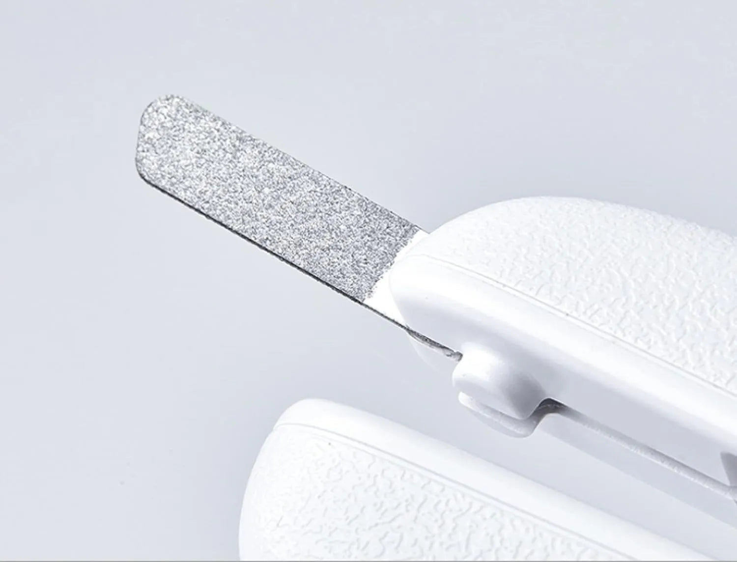 White LED pet nail clippers with transparent guard open, showing triangular steel blades and a nail file.