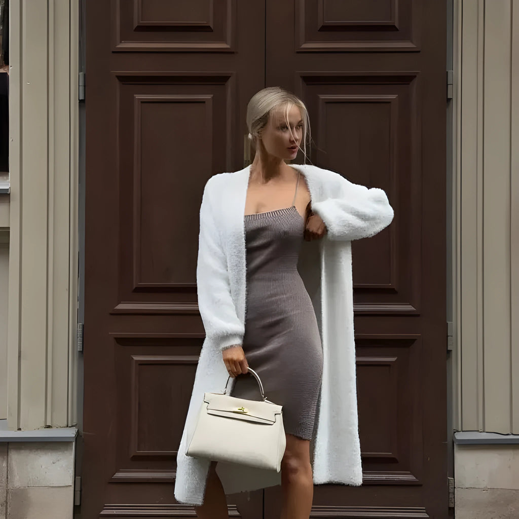 White loose-fit knitted cardigan jacket with long sleeves and an extended length.