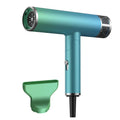 Green and purple foldable hair dryer with collapsed handle next to a suitcase, showing its compact travel size.