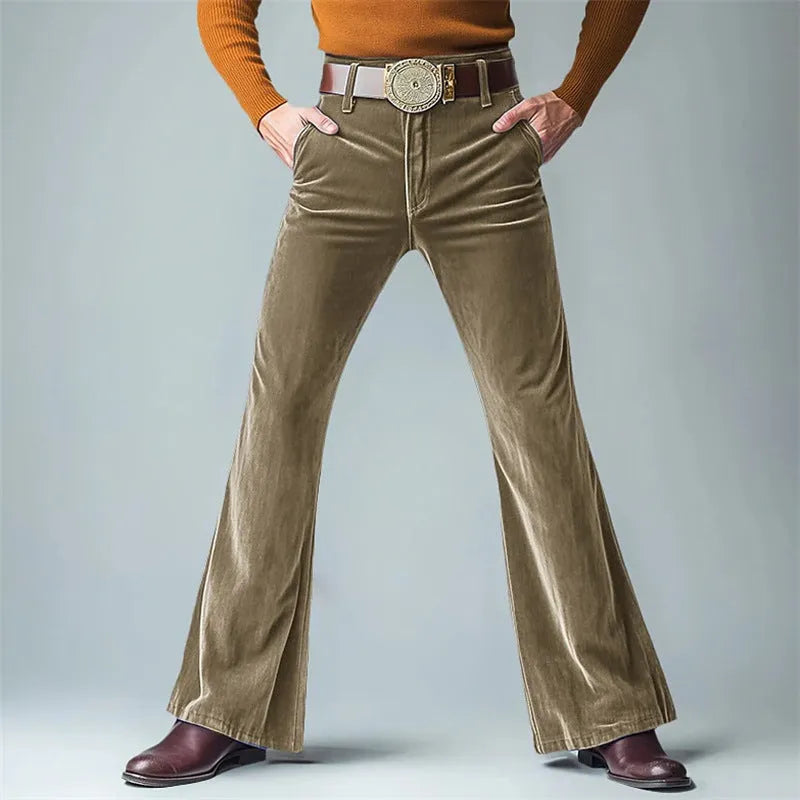 Man wearing gold velvet slim flared suit trousers in dark red for a formal banquet setting.