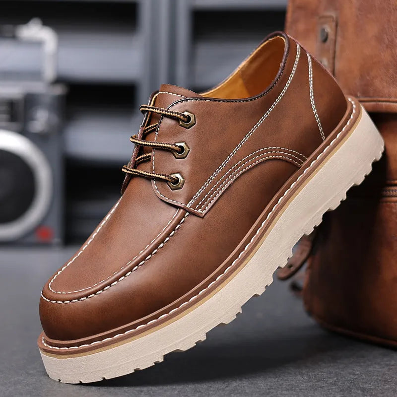 Men's black low-top Martin boots with round toe and rubber sole on wooden surface