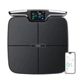 Black eight-electrode body fat intelligent weighing scale on a floor.