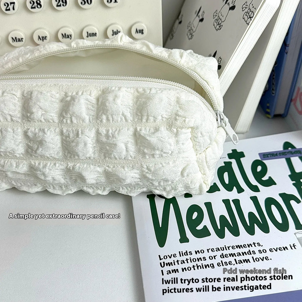 Beige and black cream puff style fabric pencil case made from polyester for pen organisation.
