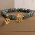 Close-up of a women's bracelet with green emerald jade abacus beads and a silver-toned alloy safety lock clasp.