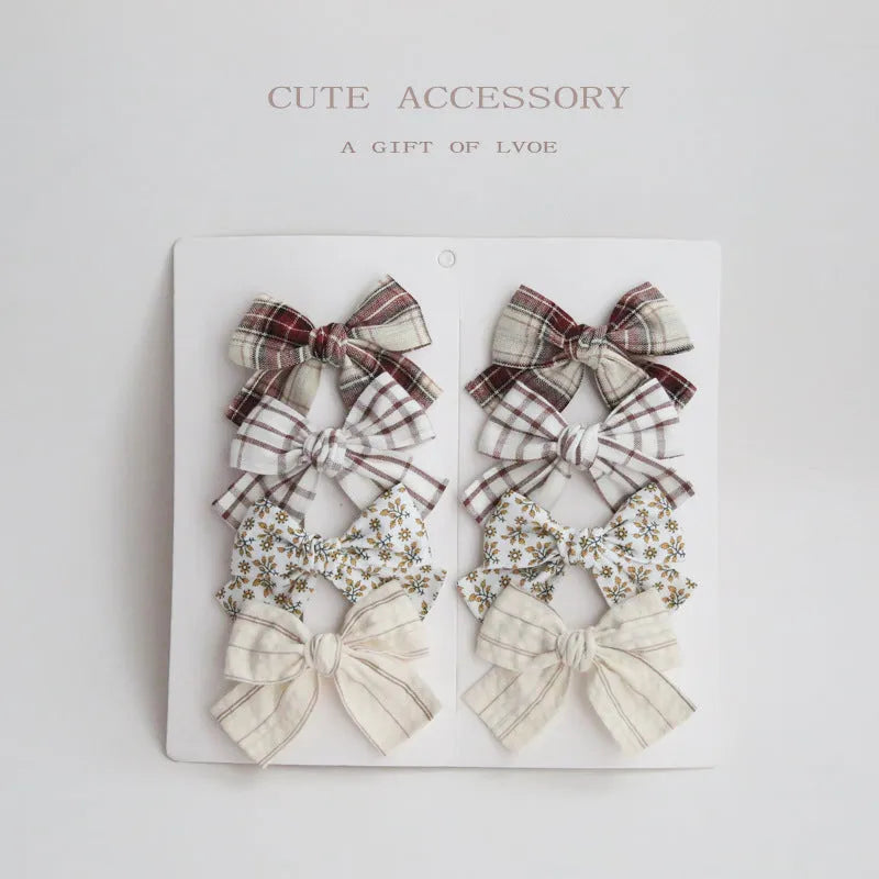 Children's dovetail bow hairclips in eight colour patterns including grid dots and floral designs