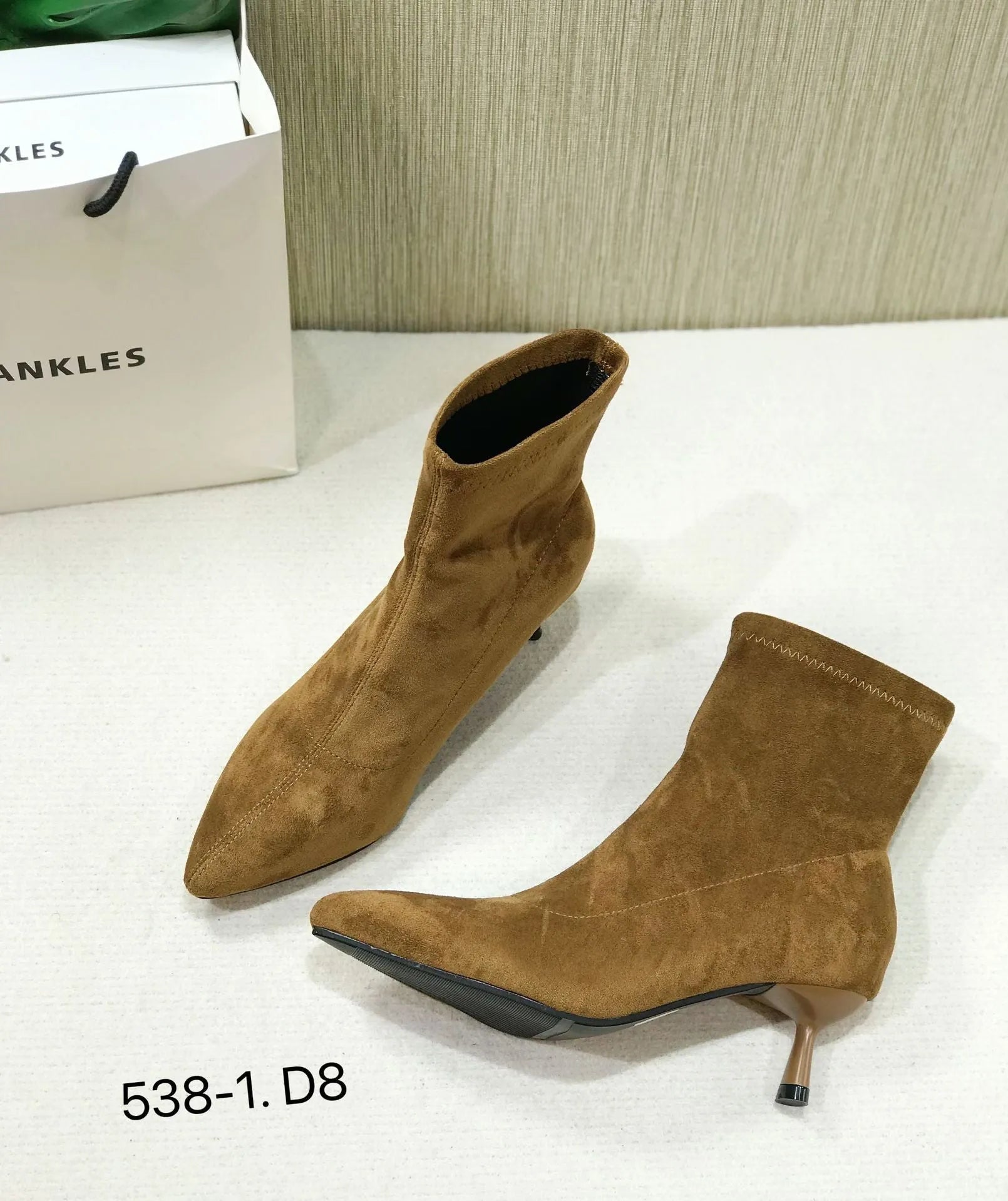 Women's black pointed toe ankle boots with stiletto heel on a plain background