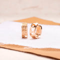 Rose gold electroplated earrings with hollow three-heart design in circular shape