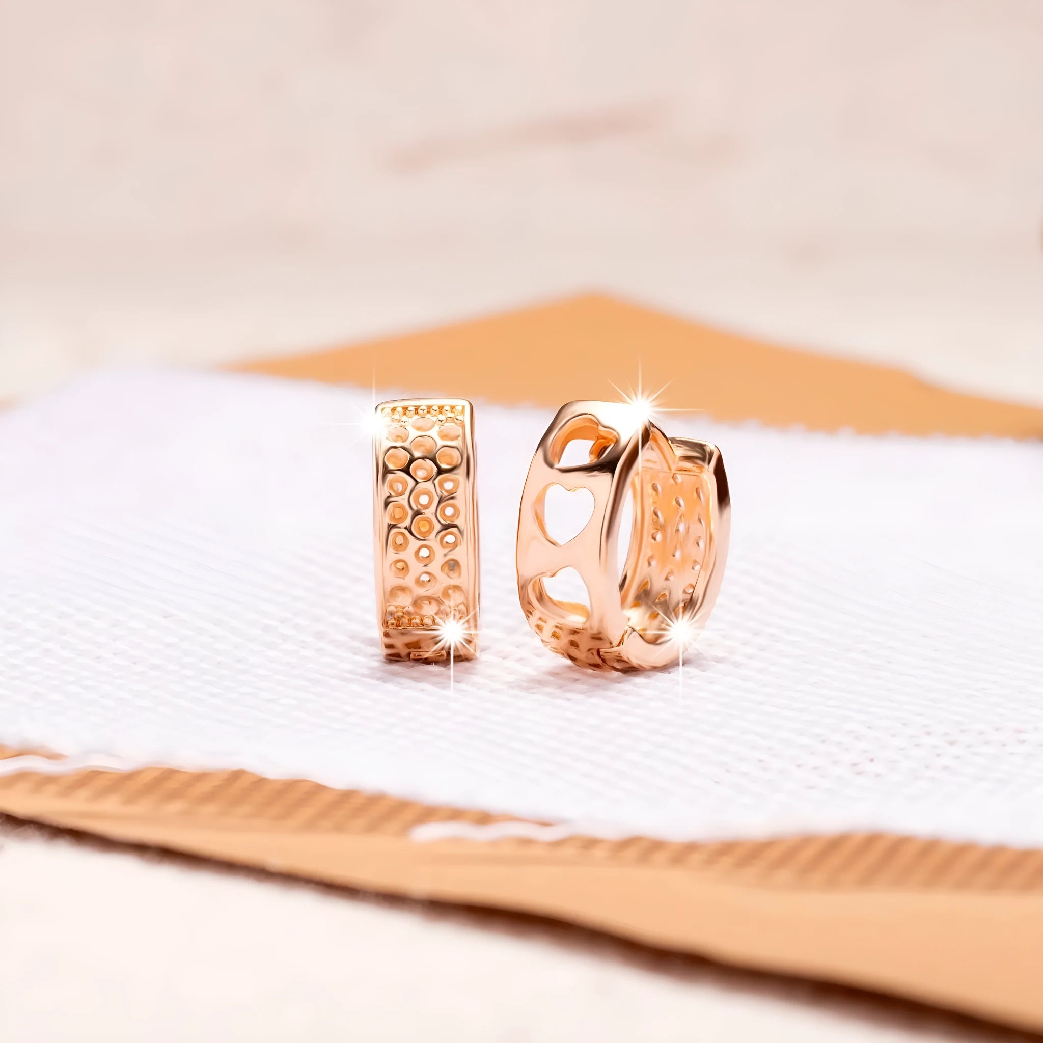 Rose gold electroplated earrings with hollow three-heart design in circular shape