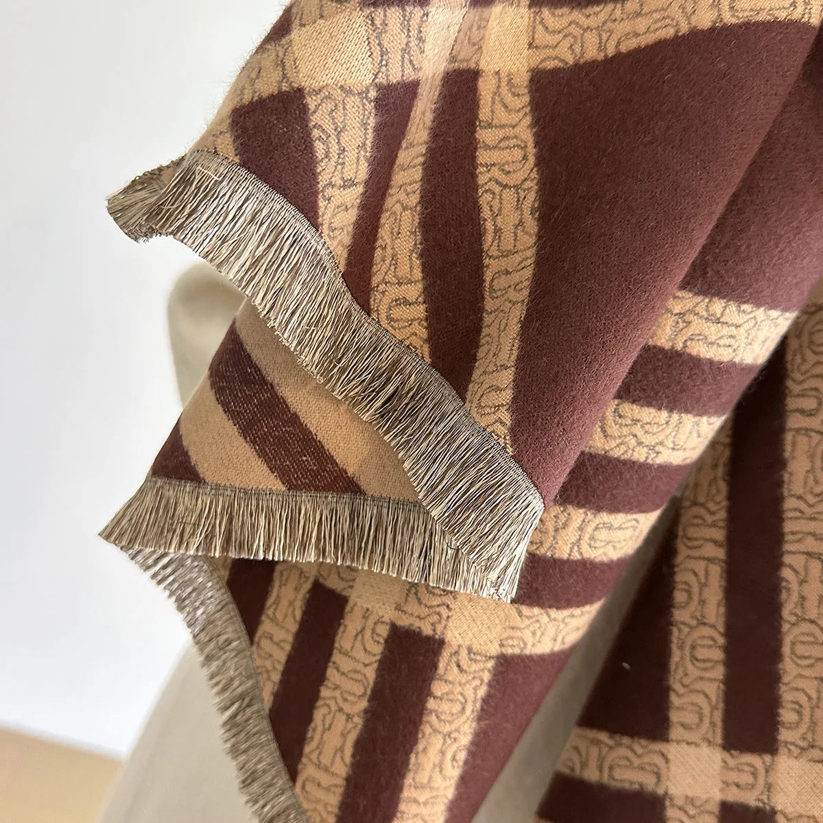 Mid-length brown cashmere-like scarf with tassel ends laid flat.