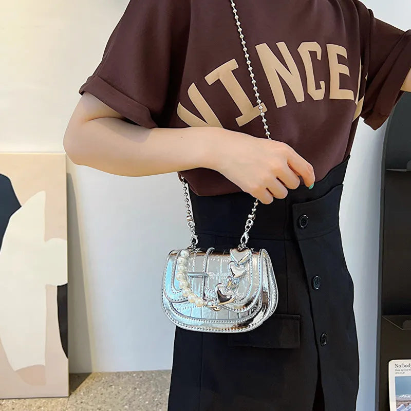 Women's silver PU crossbody bag showing horizontal square tote saddle shape and single shoulder strap