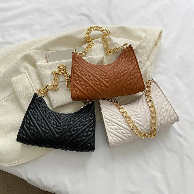 Brown pleated PU leather baguette bag with a gold-tone chain shoulder strap and a soft top handle.