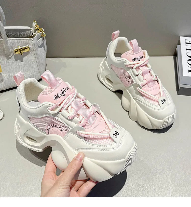 Women's pink casual sneakers with cross shoulder straps and a thick mid-heel sole.