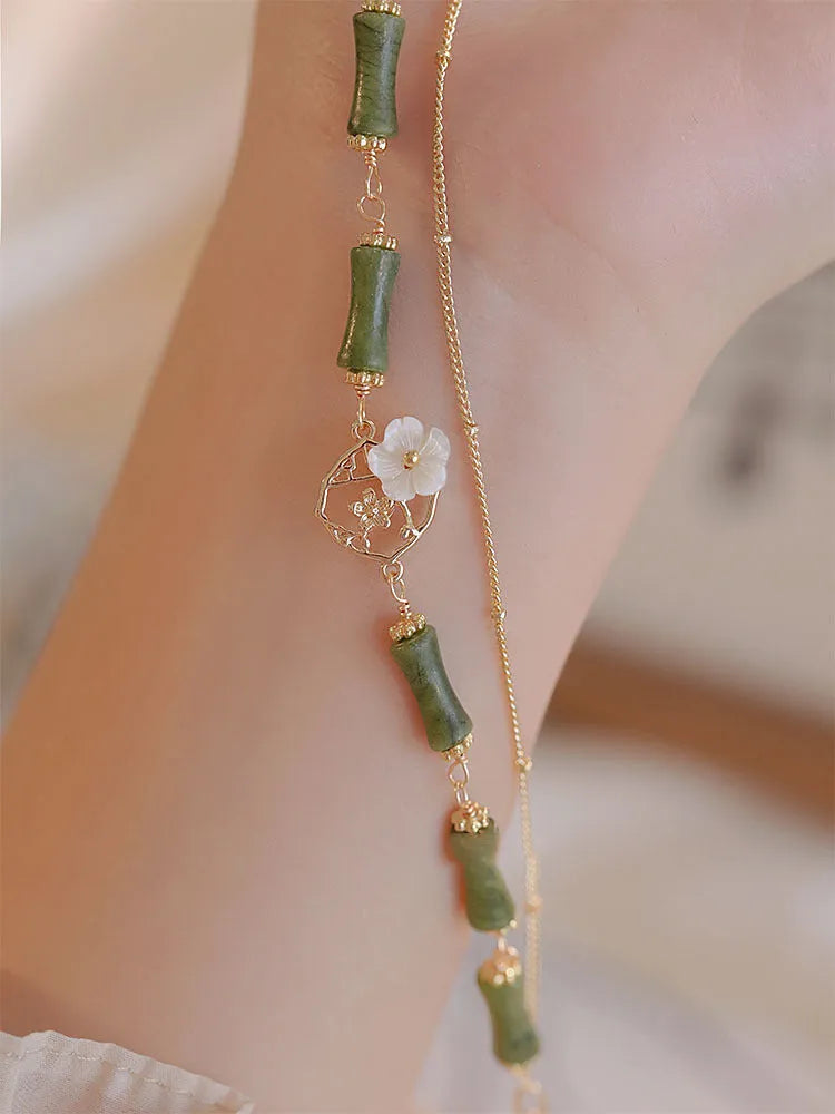 Handcrafted natural olivine bracelet with double layer design and twin Bells of Ireland charms.