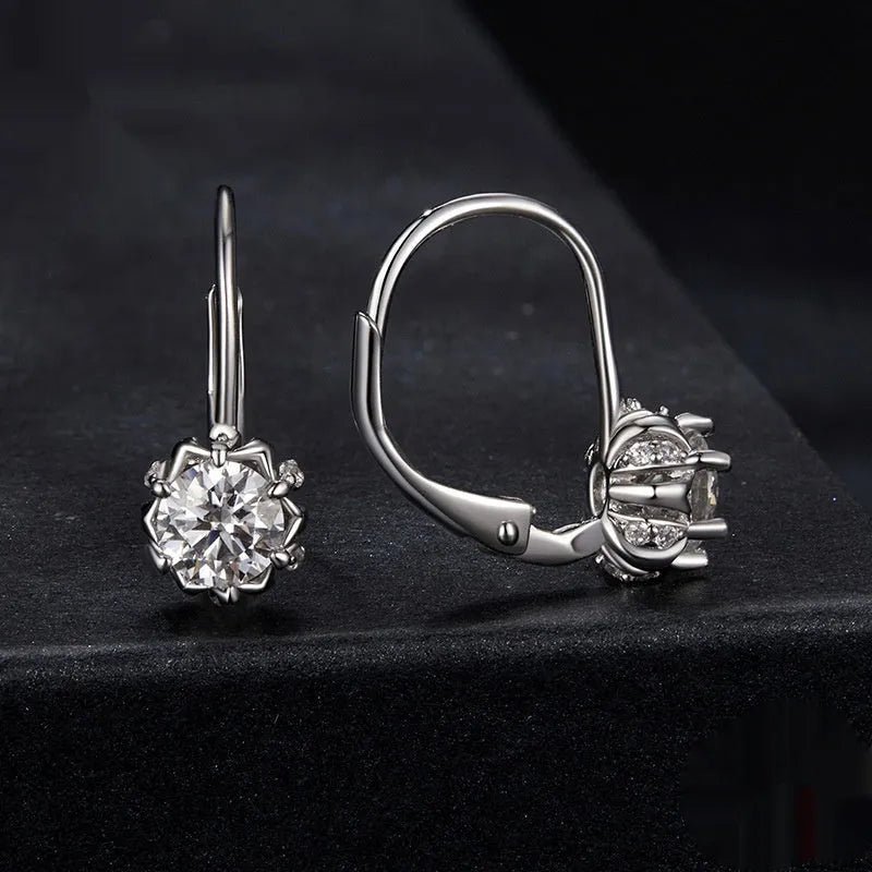Close-up of a sterling silver flower bud ear clip with a white gold plated finish and a central moissanite stone.