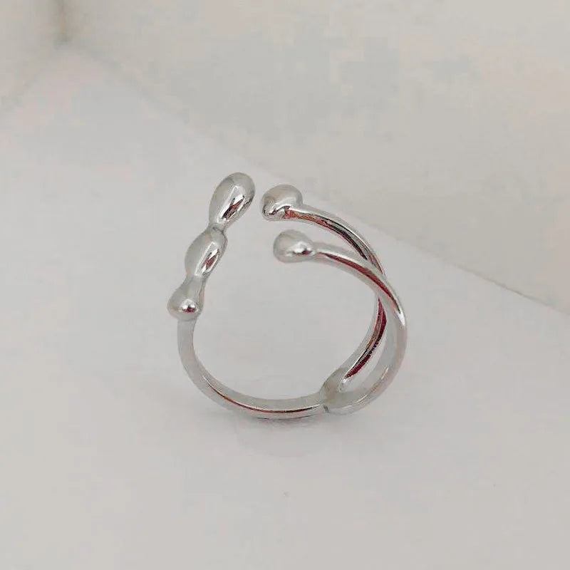 Brass opening ring with circle and sphere design in gold finish on finger