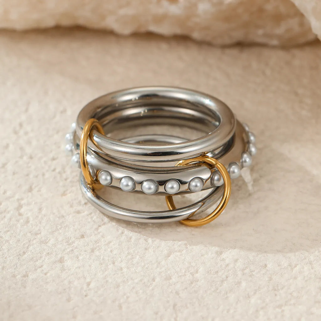 Gold plated stainless steel stacked ring set in three colour variants on a hand.