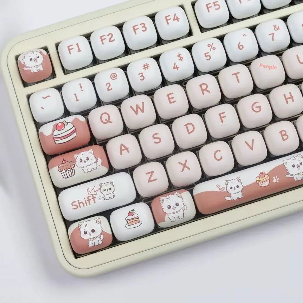 Close-up of a rounded mechanical keyboard key cap with a colourful cartoon dessert cat character print.