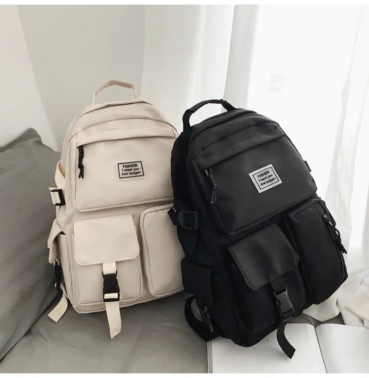 Black and white nylon student backpack with laptop compartment, showing three-dimensional pocket.