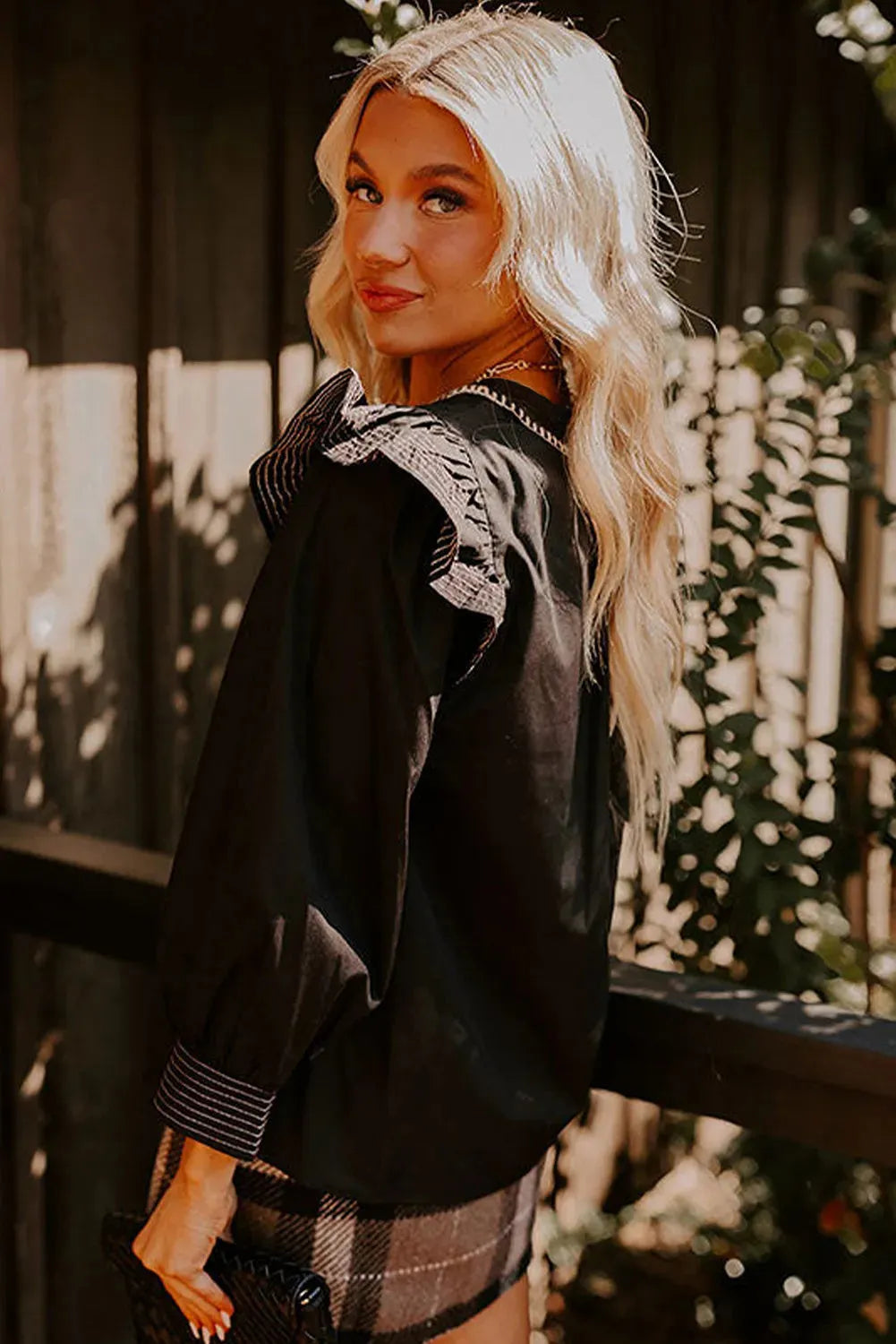 Black long sleeve blouse with V-neck, contrast stitching and ruffle sleeve detailing
