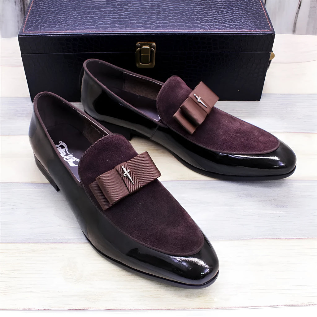Men's black patent leather dress shoes with a tassel detail and low-top design on a rubber sole.