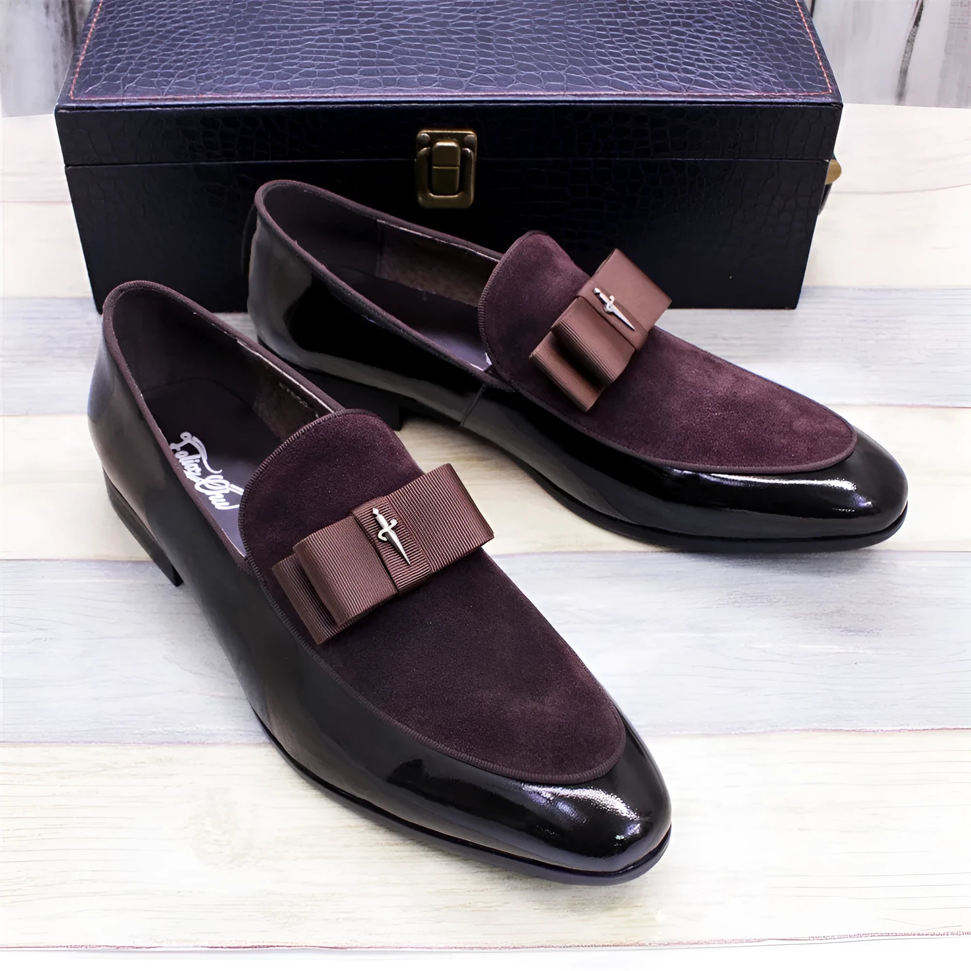 Men's black patent leather dress shoes with a tassel detail and low-top design on a rubber sole.