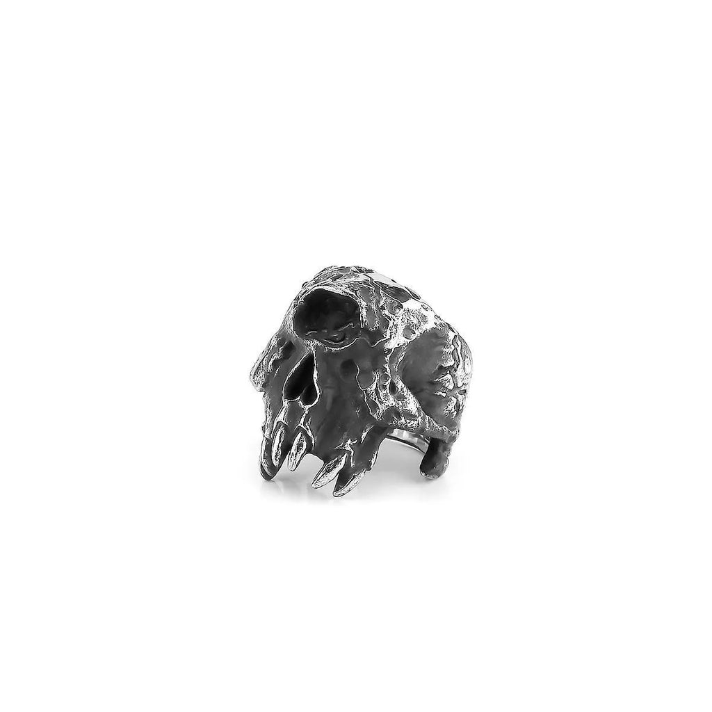 Silver-toned alloy skull ring with a detailed one-eyed design on a black background.