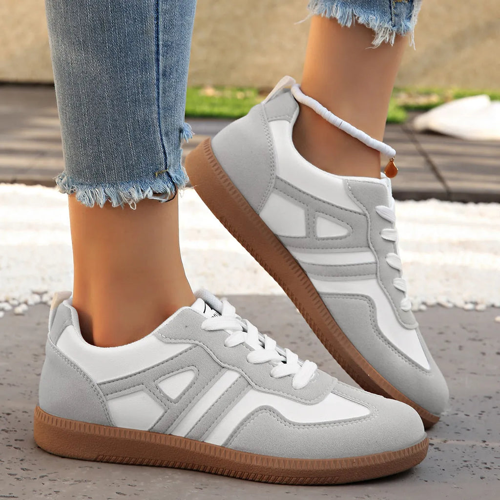 Women's retro style lace-up jogging shoes in grey with a cross strap and low platform heel.