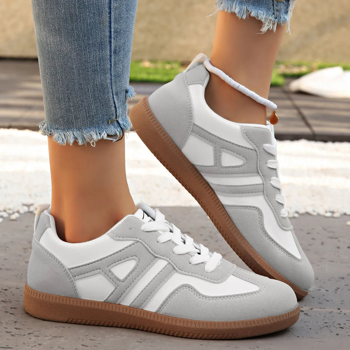 Women's retro style lace-up jogging shoes in grey with a cross strap and low platform heel.